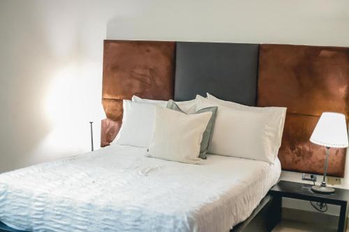 圣多明各ARMONIA 408 APARTMENT IN GAZCUE的一间卧室配有带白色床单和枕头的床。