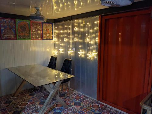 新德里HOTEL THE CUBE STAY的墙上灯火的房间里一张桌子和椅子