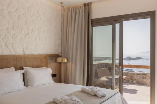 萨鲁Calma Suites Mykonos的酒店客房,配有带毛巾的床