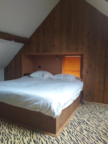 OpwijkVilla Blanco的一间卧室配有一张带木墙的大床