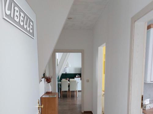 吕本Spreewald Unterkünfte "alte Zigarrenfabrik" Familie Häfner的一间拥有白色墙壁的走廊和用餐室