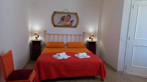 莱韦拉诺La casa di Mela的一间卧室配有红色的床和2条毛巾