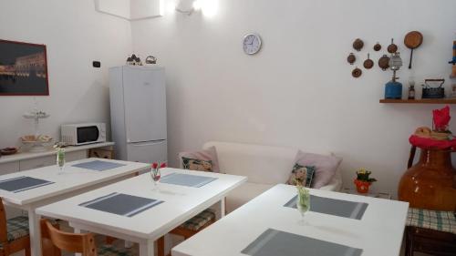 莱韦拉诺La casa di Mela的厨房配有2张白色桌子和冰箱