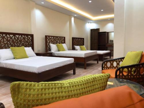 锡基霍尔PMG Islandscape Resort的一间设有两张床和一张桌子及椅子的房间