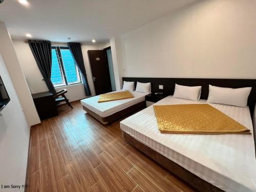 清化Phú Quý Hotel的酒店客房设有两张床和电视。