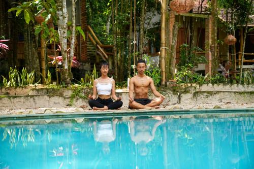 富国Valley Village Phu Quoc的坐在游泳池旁冥想的男女