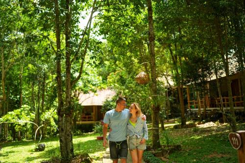富国Valley Village Phu Quoc的站在树林中的男人和女人