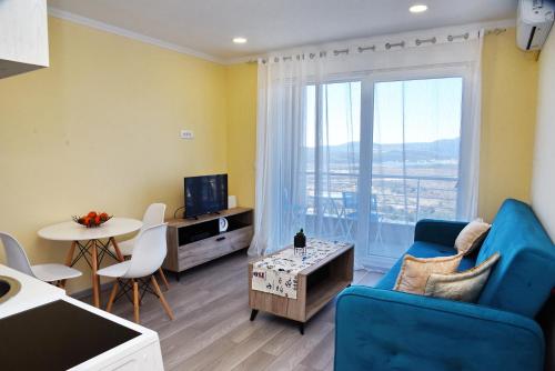 科托尔Sunset Apartments的客厅配有蓝色的沙发和桌子