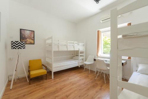 尼什Sleep Hostel的一间卧室配有一张双层床和一张桌子及椅子