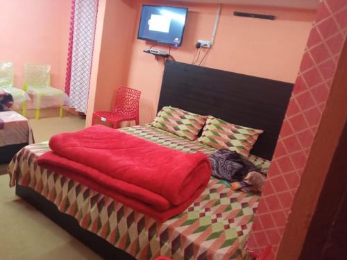 乔斯希马特Badri Kedar Hometay的一间卧室配有一张带红色毯子的床