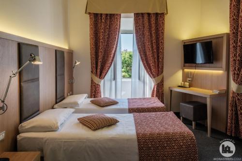 罗马罗马瓦尔德斯酒店的酒店客房设有两张床和窗户。