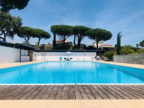 格里莫Villa-Golfe de Saint-Tropez/Accès plage privée的一个种有树木的大型蓝色游泳池