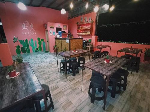 BaclayonPamujo Hostel的餐厅设有木桌、椅子和粉红色的墙壁