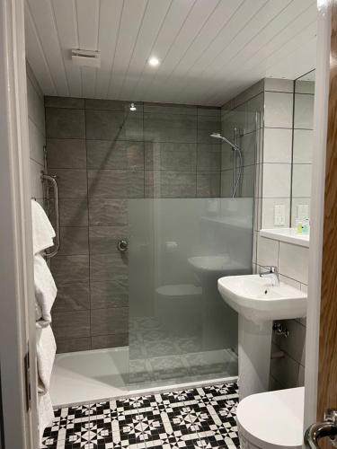 利明顿南草坪酒店 的带淋浴、卫生间和盥洗盆的浴室