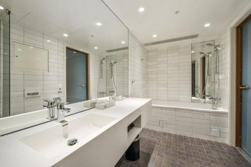 特罗姆瑟克拉丽奥边缘酒店的白色的浴室设有水槽和浴缸。