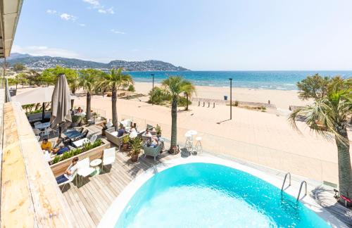 罗萨斯Hotel Maritim的享有海滩和度假村游泳池的景致