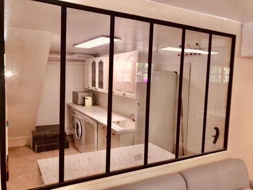 Boissy-lʼAillerieAppartement 120m2 dans maison avec piscine的厨房里设有大玻璃窗和水槽