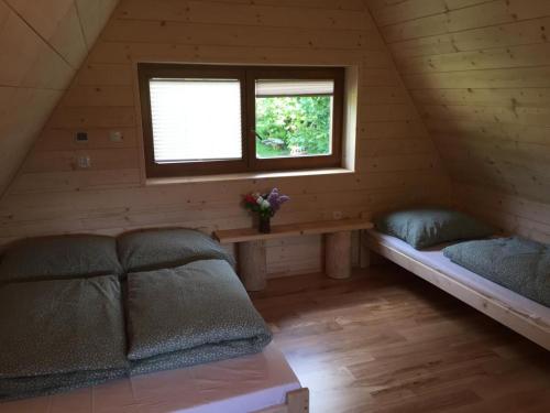ŻabnicaChatka z sauną nad rzeką的小屋内带床和窗户的房间