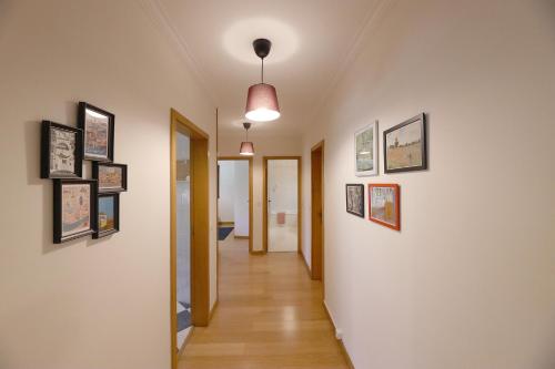 加亚新城FLH Gaia Valadares Comfy Apartment的墙上有很多照片的走廊