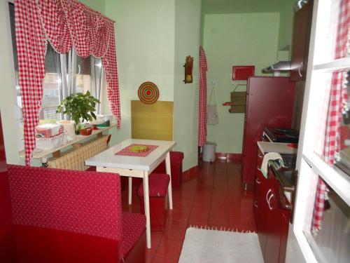 皮罗特Apartman "Dom Stankovića"的一间带桌子和红色椅子的小厨房