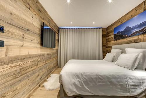 夏蒙尼-勃朗峰Amazing chalet的卧室设有白色的床和木墙