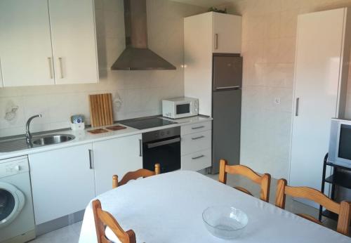 科巴罗Combarro vivienda completa próxima a sanxenxo的厨房配有桌子、水槽和微波炉