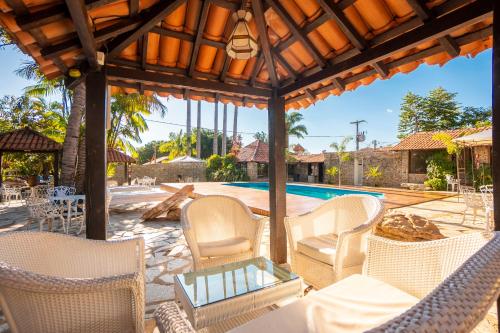 皮雷诺波利斯Pousada Villa das Pedras的一个带白色椅子的庭院和一个游泳池