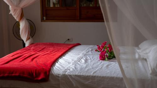 帕洛米诺Rustiko Palomino Sierra Nevada的一张白色的床,上面有红毯和鲜花