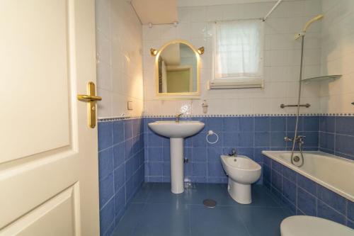阿罗纳Sunny-Harbour的蓝色瓷砖浴室设有水槽和卫生间