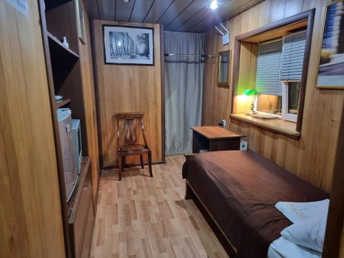 巴库Guest House Tikhiy Dvorik的一间卧室配有一张床、一张书桌和一个窗户。