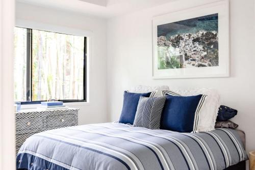 努萨角BERRIMA LUXE - Noosa Hill Home - Heated Pool的一间卧室配有一张带蓝色和白色枕头的床