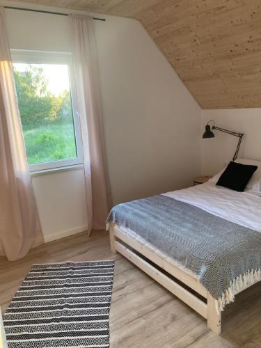 里沃Domki Kalimera Rewal的一间卧室设有床、窗户和地毯。