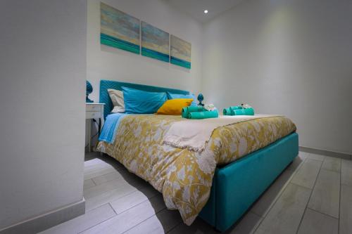 锡拉库扎La Casetta del Ronco1 Ortigia的一间卧室配有蓝色的床,铺有蓝色和黄色的床单
