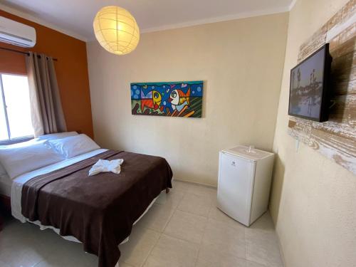 福塔莱萨Refúgio Pousada Fortaleza的一间卧室配有一张床和一台电视