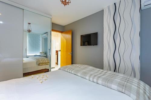 巴西利亚Premier Residence的卧室配有白色的床和镜子