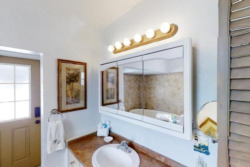 圣奥古斯丁Crescent Beach Cottage的一间带水槽和镜子的浴室