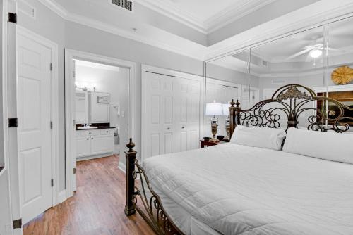 巴拿马城海滩Calypso 2-2307 West的一间白色卧室,配有一张大床和一个厨房