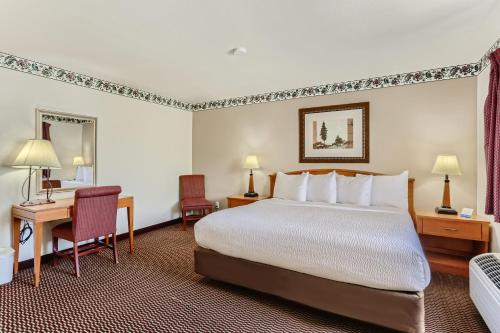 拉夫兰Baymont by Wyndham Loveland - Fort Collins Area的配有一张床和一张书桌的酒店客房