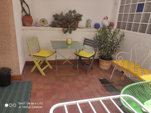 佩皮尼昂Grande chambre avec garage dans quartier historique的庭院设有黄色的椅子和桌椅