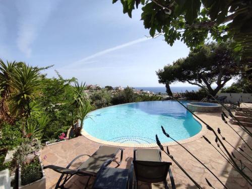 拉格尼西3-house Villa with amazing infinity pool的一个带椅子的游泳池,享有海景