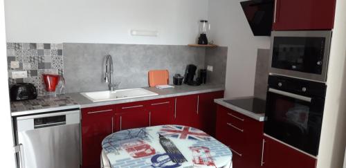 BaugéTriplex tout confort, plein centre ville Bauge en Anjou的一个带红色橱柜和水槽的小厨房
