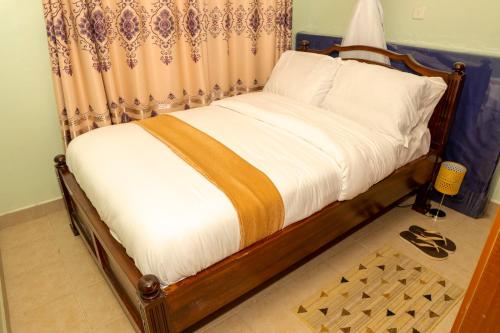 基苏木Bonaventure Apartment的一间卧室配有一张带窗帘的床和床边镜。