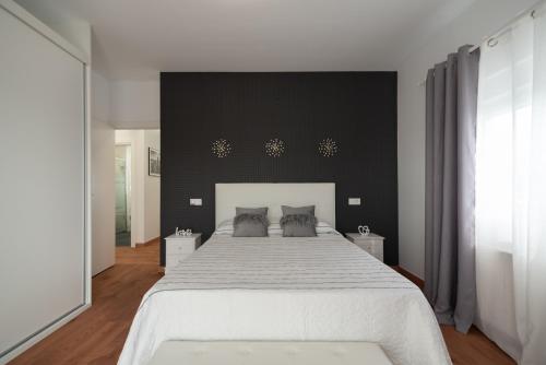 巴里亚纳DREAM HOUSE的一间卧室设有一张大床和黑色墙壁