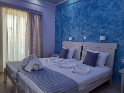 凯法洛斯Villa Bel Passo Apartments的一间卧室设有两张带蓝色墙壁的床