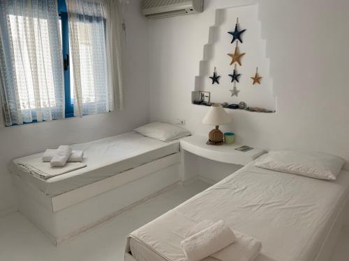 马克里亚罗斯Blue Sea Villa & Apartments的白色客房的两张床,墙上有星星