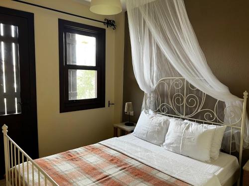 萨利杰尔梅韩精品酒店 的一间卧室配有一张带天蓬和窗户的床