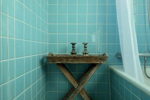 希茨海尔斯Hotel Strandlyst Badehotel的蓝色瓷砖浴室设有浴缸旁的木架