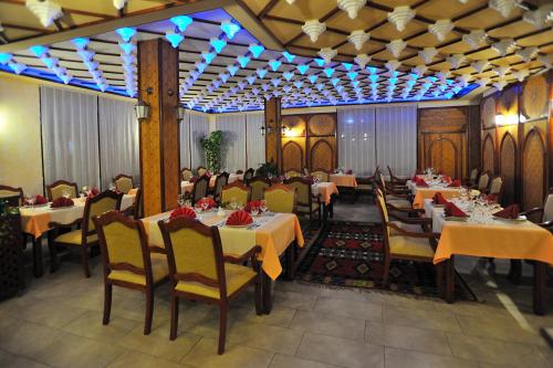 莫斯塔尔莫斯塔尔旧城精品酒店的一间设有桌椅的餐厅,以及坐在里面的人