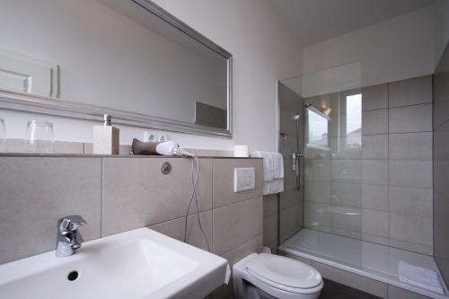 希尔泽Hotel Galerie的一间带水槽、卫生间和镜子的浴室