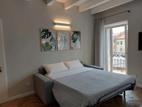 维罗纳HomeThirtyFour的一间卧室设有一张床和一个大窗户